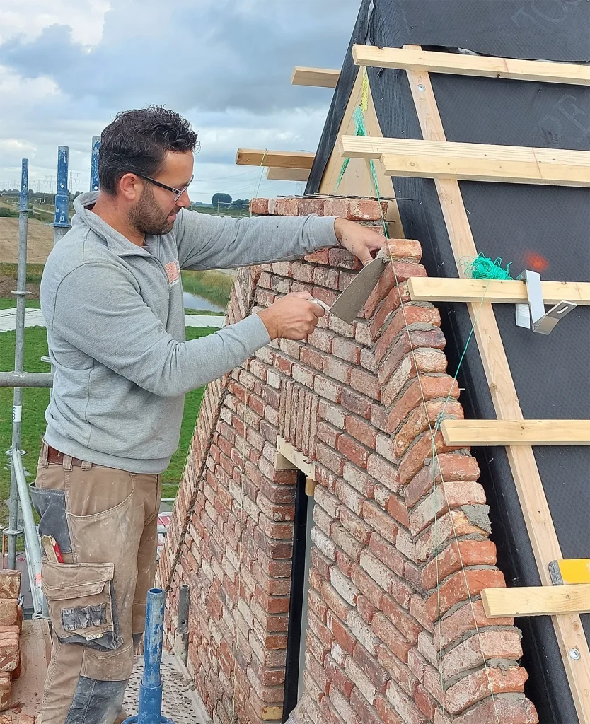 B van Beek, ervaren metselaar in Zeeland, bezig met metselwerk project
